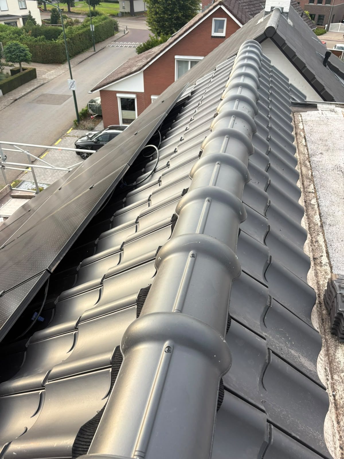 Nieuwe keramische nokvorsten terwijl de zonnepanelen worden teruggeplaatst in Maarheeze