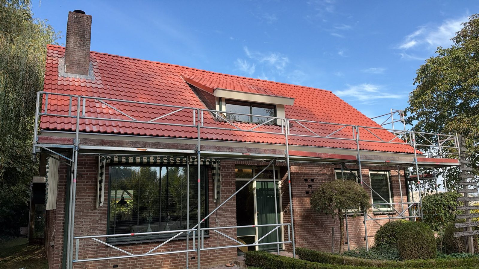 Nieuwe Sneldek pannen in natuurrood rond de dakkapel